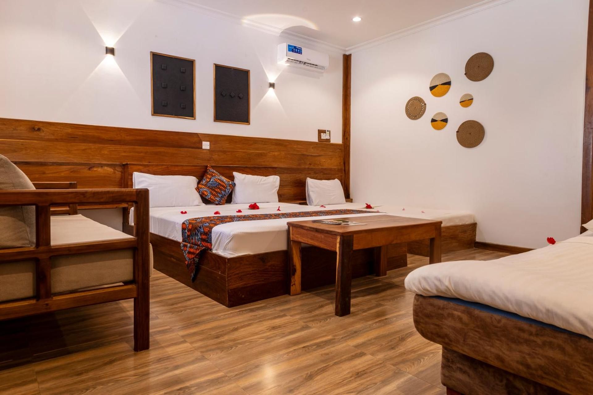 Family Room: a king bed and single beds in wooden frames, a coffee table and a sofa.